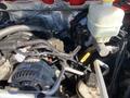 The engine compartment of a 2015 RAM 2500 showing the alternator reservoir and various engine components with wiring and hoses visible