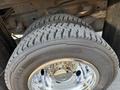 Close-up of a large, rugged tire mounted on a shiny chrome wheel designed for a 2011 Dodge Ram 5500 with deep treads for traction
