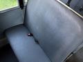 A gray vinyl seat from a 2014 International 4300 with two seatbelt buckles attached