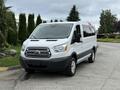 2017 Ford Transit T150 XLT van in white with a distinct front grille and large windows facing forward