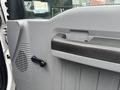 The interior door panel of a 2014 Ford F-550 showing the handle speaker grille and a knob for adjustments
