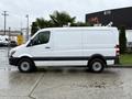 A white 2017 Mercedes-Benz Sprinter van is parked, featuring a sleek design with a high roof and a paneled side for cargo storage