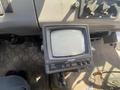 A vintage black monitor with a square screen labeled Voyager featuring buttons for power camera contrast and volume mounted in a vehicle interior