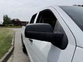 A 2018 Chevrolet Silverado 1500 with a black side mirror and a white body is parked on the side of a street