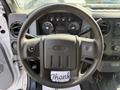 A 2011 Ford F-350 SD steering wheel with control buttons and instrument cluster visible behind it