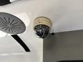 A round surveillance camera mounted on the ceiling of a vehicle