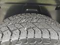 Close-up of a heavily treaded tire showing intricate patterns and dirt on the surface of a vehicle tire mounted on a 2016 RAM 1500