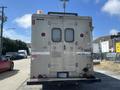 A 2009 Workhorse W62 with a worn gray exterior and multiple doors at the rear displaying ventilation grates and a light on the top