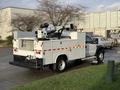 A 2010 Ford F-550 utility truck equipped with a crane and service body features multiple compartments for tools and equipment on the rear and sides