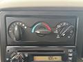 Dashboard controls of a 2013 International DuraStar 4300 featuring three dials for air conditioning and heating and a digital clock displaying 106 PM