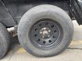 A black wheel from a 2005 Katolight SED60FPJ4 with visible bolts and tire tread labeled Rhoden