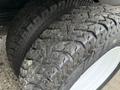 Close-up of a 2019 Ford Econoline tire showcasing a rugged tread pattern with visible wear and dirt accumulation