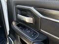 Close-up of the door handle and window controls of a 2023 RAM 3500 showcasing a sleek design and modern materials