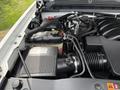 Engine compartment of a 2018 Chevrolet Silverado 1500 showing the air intake system battery and coolant reservoir