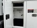 A 2013 Freightliner 114SD with an open storage compartment revealing hooks and a clean interior space