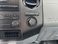 Dashboard controls of a 2013 Ford F-250 SD featuring climate control knobs and a 12V power outlet