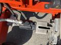 A close-up view of a hydraulic control valve on a Wallenstein Wx540-0RA tow-behind industrial log splitter showcasing metal components and hydraulic hoses