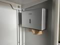 A silver Aike hand dryer mounted on a wall