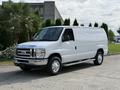 A white 2013 Ford Econoline van with a smooth exterior and chrome bumpers positioned on a paved surface