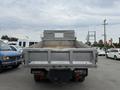A silver 2004 Ford F-350 SD truck with a flatbed and tailgate raised parked in a lot