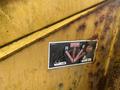 A close-up view of a safety label featuring a stop sign and warning symbols for a Vermeer Corporation BC1000XL machine with cautionary graphics about moving parts