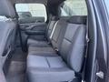 Interior view of the back seat of a 2011 Chevrolet Avalanche showing three seats with seatbelts in a dark fabric upholstery