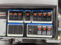 Control panel of a 2009 UD Trucks UD 3300 featuring numerous switches for functions such as hopper dump water flow and lights