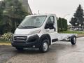A 2023 RAM Promaster 3500 chassis cab with a white exterior and open bed design parked on a paved surface