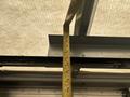 A measuring tape extending to a specific length against a metallic edge inside a vehicle, likely a 2012 Ford E-450, indicating a measurement being taken