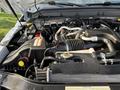Close-up of the engine compartment of a 2015 Ford F-550 featuring various hoses wires and components including the air intake and battery
