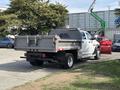 A 2013 RAM 5500 truck with a flatbed and toolboxes in the rear parked on a gravel surface