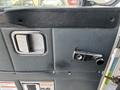 The interior door handle and locking mechanism of a 2011 Autocar Xpeditor with a textured black surface and chrome accents
