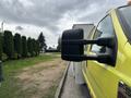 A yellow 2010 Ford F-550 Super Duty with prominent side mirrors visible from the passenger side angle