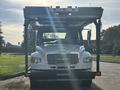 A 2022 Freightliner M2 106 truck featuring a front-mounted platform and multiple lights on the roof with a silver grille and large windshield.
