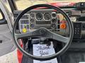 Interior view of a 1999 Freightliner FL80 truck showing the steering wheel dashboard gauges and control panels