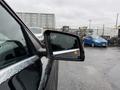 A close-up of the side mirror of a 2016 Mercedes-Benz GLA-250 with water droplets on its surface and a warning indicator visible
