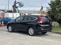 A black 2014 Honda CR-V parked with its rear visible showcasing its sleek design and alloy wheels