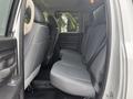 The interior of a 2016 RAM 1500 showing the back seat area with two rear seats and a third folding seat in a light gray fabric