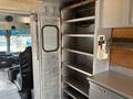Interior view of a 2011 Workhorse W62 showing metal shelving cabinets and a driver's seat visible on the left side