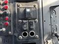 The control panel of a 2011 Autocar Xpeditor featuring various switches and buttons for functions like wash and brightness adjustment