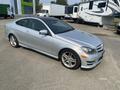 A silver 2013 Mercedes-Benz C-Class coupe is parked, featuring sleek lines, sporty rims, and a sunroof