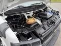 A 2013 Chevrolet Express engine with various components including the coolant reservoir air intake and wiring visible under the raised hood