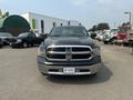 A 2015 RAM 1500 pickup truck in black with a prominent chrome grille and headlights facing forward