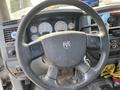 A close-up of the steering wheel of a 2009 Dodge Ram 5500 showing various controls and instrument panel with gauges