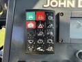 Control panel of a 2013 John Deere 710K featuring various buttons and indicator lights for operations and functions