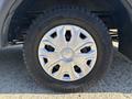 Close-up of a silver alloy wheel with a black tire from a 2017 Ford Transit-350 showing five spokes and a rugged tread pattern