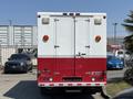 A 2007 GMC C4500 TopKick truck with a white and red exterior seen from the rear featuring two orange lights and a loading ramp on the back