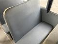 A gray bench seat in a bus with a smooth texture and minimalist design