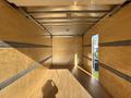 An empty interior of a 2022 Lion Lion6 truck featuring wooden paneling and metal support rails along the sides