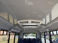 Interior view of a 2017 Chevrolet Express showing a grey ceiling with a central air conditioning unit and rows of blue passenger seats